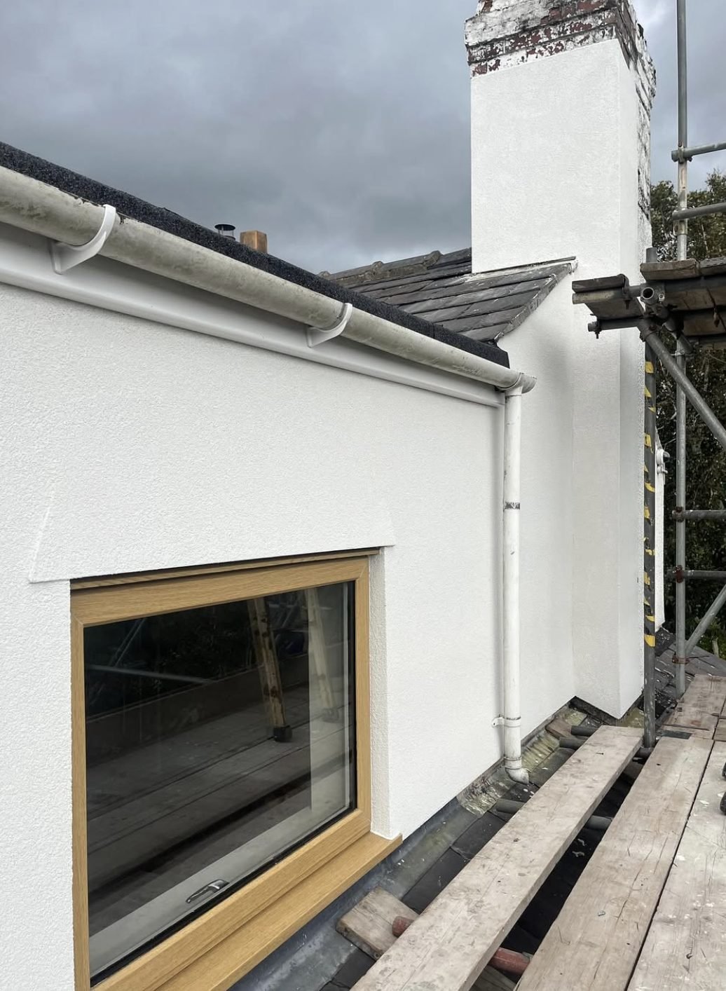 Chimney stack and dormer side in new white render, seen from the scaffold