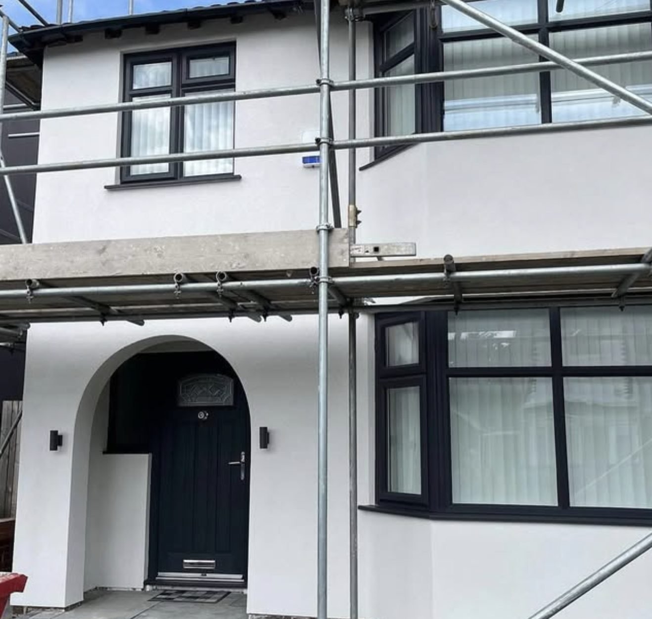 Semi-detached house in fresh white render with scaffolding still standing