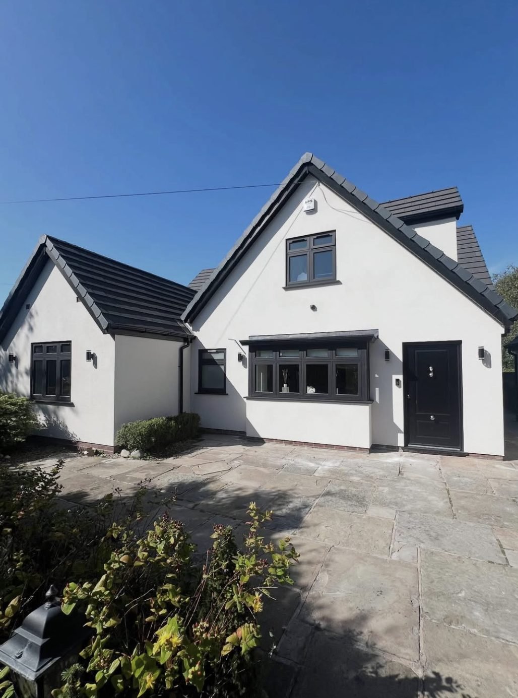House with steep white rendered gables and dark grey windows