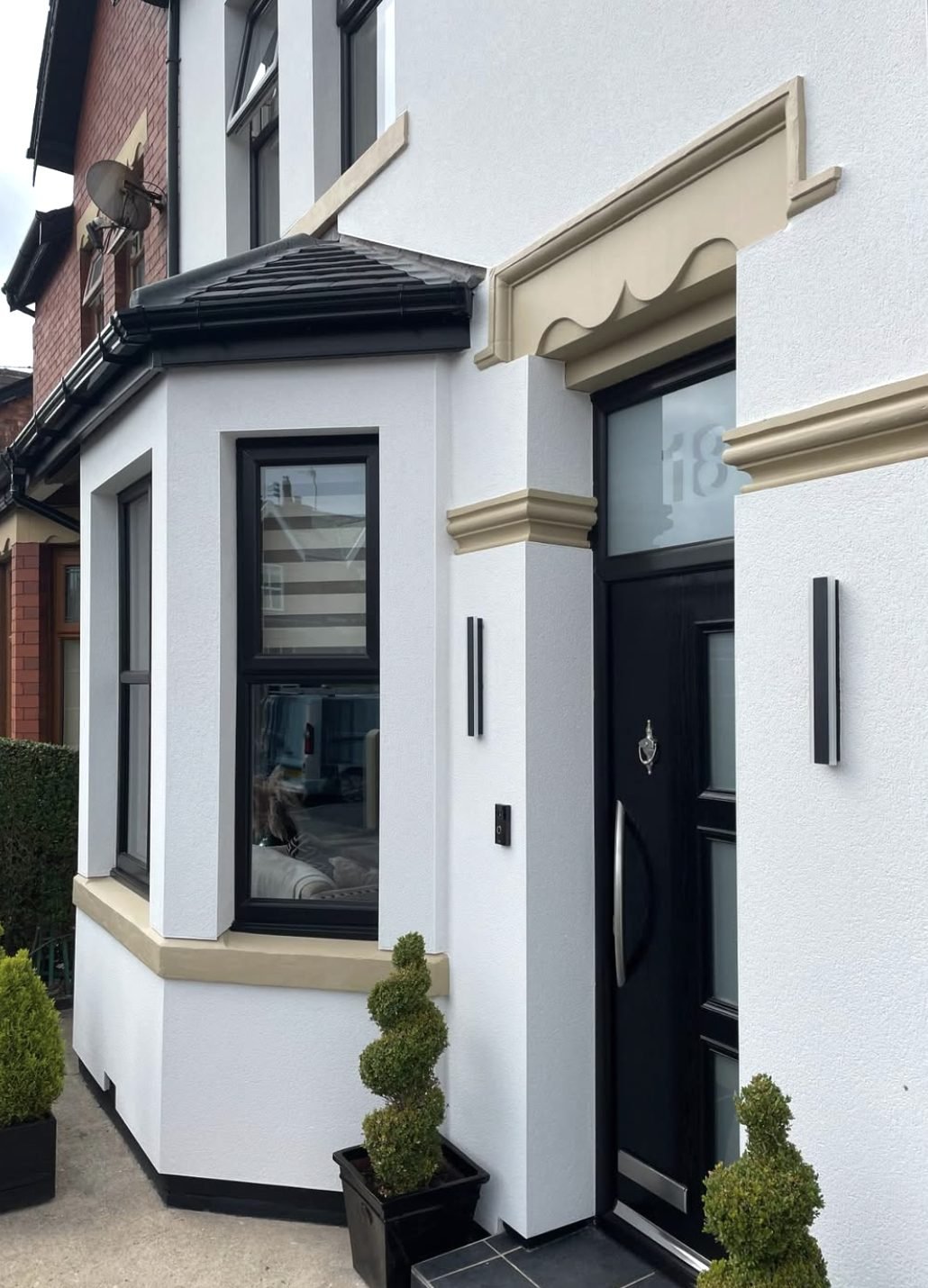 White rendered entrance and bay with a cream door surround and band